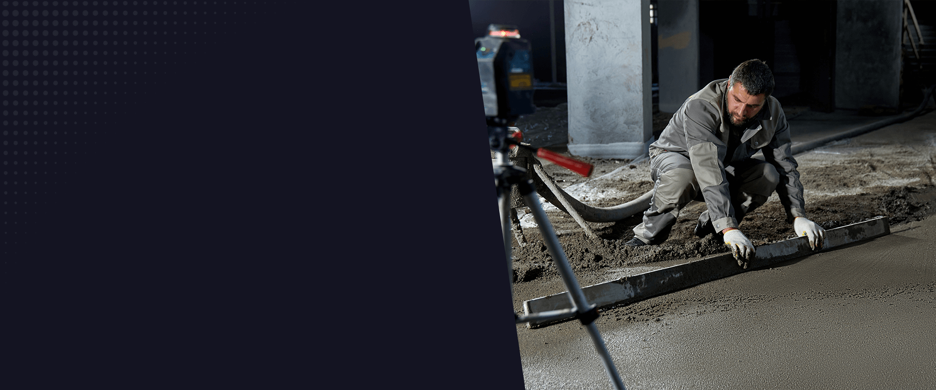 A construction worker in a gray uniform and white gloves is using a metal float tool to smooth freshly poured concrete on a construction site. The worker is crouched down, working with the tool along the edge of the concrete surface. In the background, there is a large concrete support column. The image has a dark, industrial atmosphere with muted grays and browns. The concrete surface is freshly laid, with a smooth, wet appearance. The lighting is artificial and creates subtle shadows on the construction site. The image is cropped with a dark gradient overlay in the top left corner.